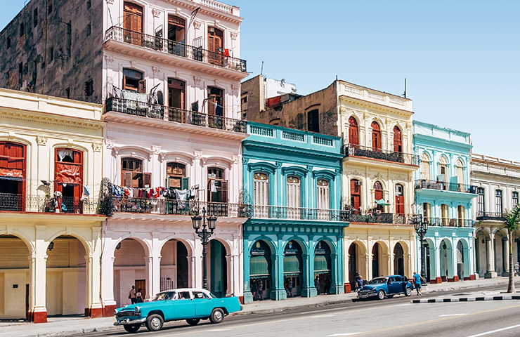 キューバのハバナのカラフルな家々とクラシックカー